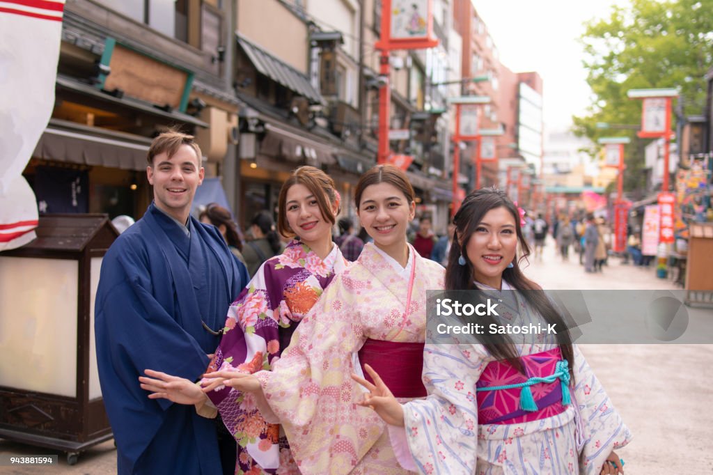 Multi-Ethnic group of people in kimono standing in traditional Japanese town Tourist Stock Photo