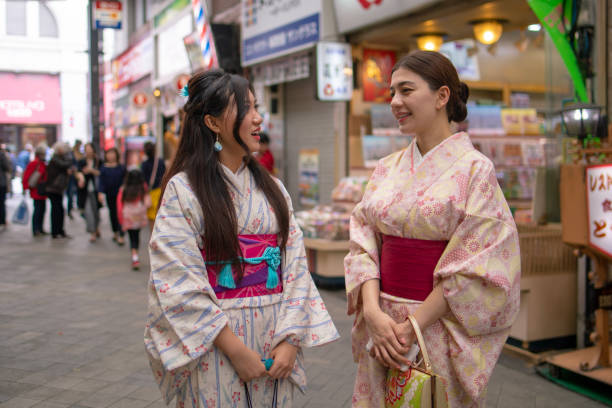 istock Young female friends in Kimono talking 943881912