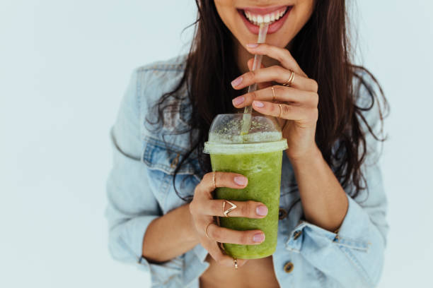 donna sorridente che beve succo fresco - juice glass healthy eating healthy lifestyle foto e immagini stock