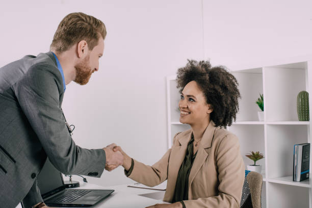 istock Joyful coworkers shaking hands and arranging an agreement 943891182