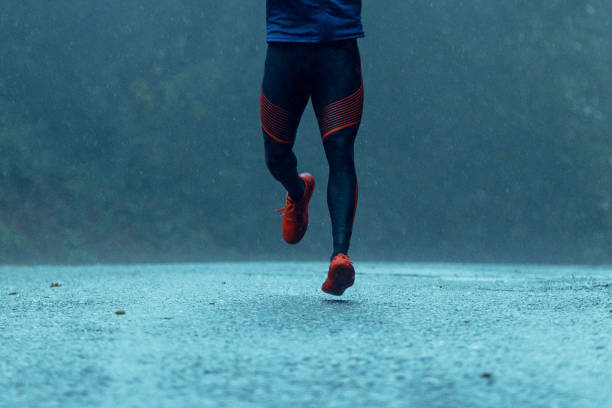 istock Motivated young man running in the rain 943893888