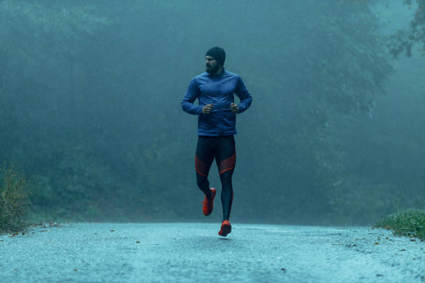 istock Motivated young man running in the rain 943897484