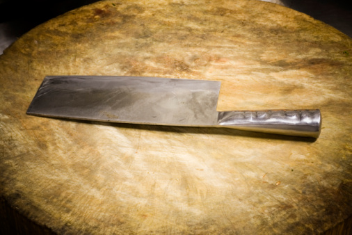 An assortment of different kitchen knives on a cutting board