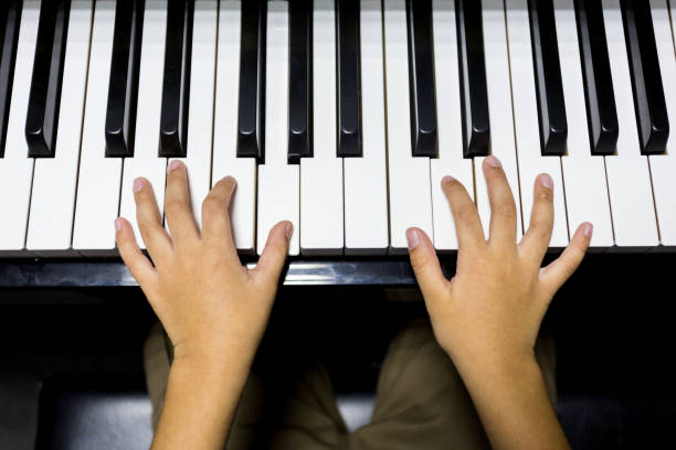 istock hands of kid playing piano 943903196