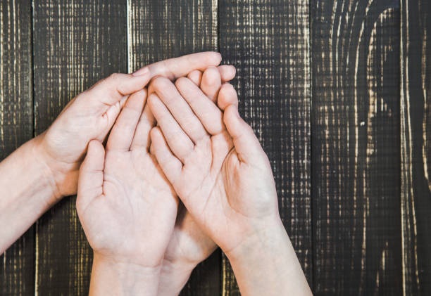 istock open palms of female and child's hands 943909886