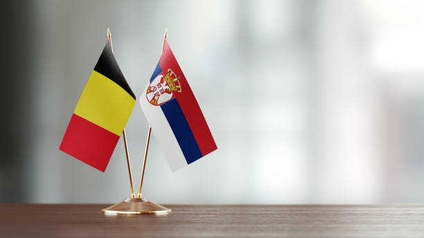 istock Belgian And Serbian Flag Pair On A Desk Over Defocused Background 943913948