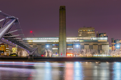This is a night view of the Tate Modern building and Millenium Bridge along the River Thames on January 17, 2018 in London