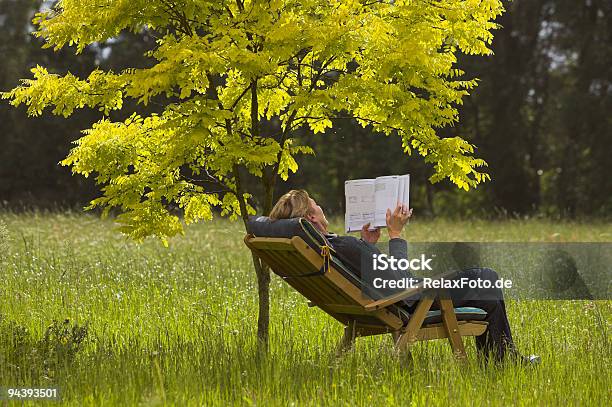 Photo libre de droit de Femme Dâge Mûr Reposant Sur La Terrasse En Plein Air Dans Une Chaise De Lecture De Livre banque d'images et plus d'images libres de droit de Activité de loisirs