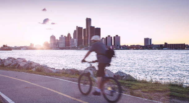 istock Man riding a bicycle by Detroit river in Windsor, Canada 943938520