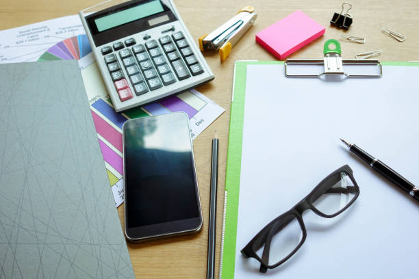 istock Businessman working on a laptop at office desk with paperwork and other objects around.(Focus only pen) 943939166