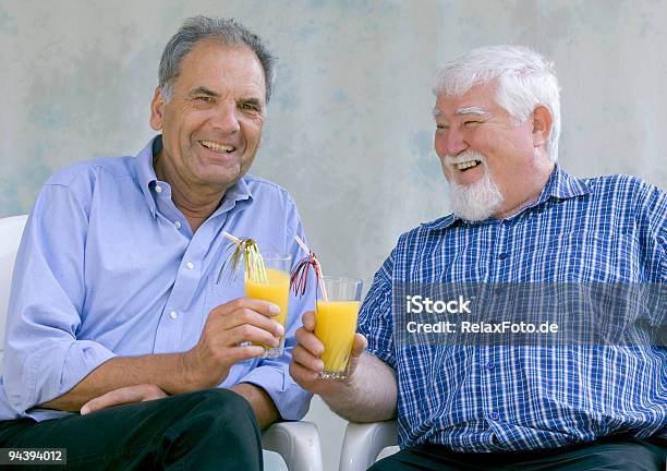 Riendo Senior Hombres Con Vasos De Jugo De Naranja Foto de stock y más banco de imágenes de 60-69 años - 60-69 años, Actividad de fin de semana, Adulto