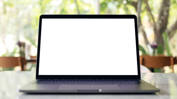 istock Mockup image of laptop with blank white desktop screen on marble table in modern cafe with nature background 943946452