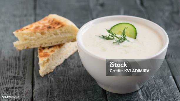 Freshly Made Tzatziki In A White Bowl With Bread On A Dark Wooden Table Stock Photo - Download Image Now