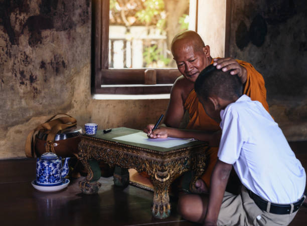 Monk teaching children books in rural temples. stock photo