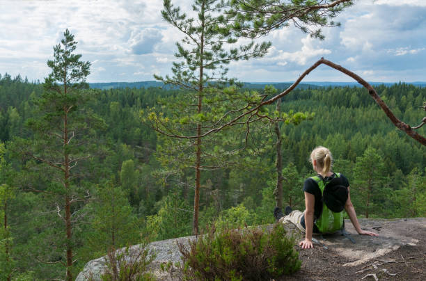 Woman hiking and looking at view Woman hiking in forest in Finland finnish culture stock pictures, royalty-free photos & images