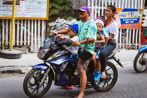 Malay, Philippines - January 10, 2016: a man riding a motorcycle with his family in Boracay island, in Malay City, Philippines.
