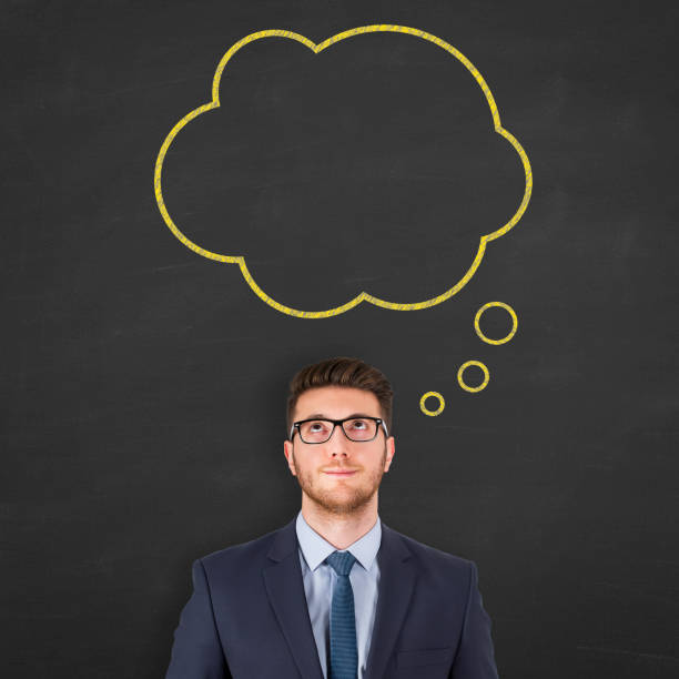 istock Business man standing next to thought bubble drawn on chalkboard 943963896
