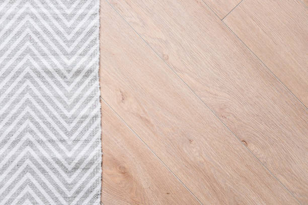 Laminate parquete floor. Light wooden texture. Thin gray and white carpet. Minimalism interior design concept