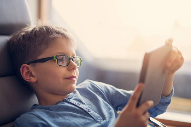 маленький мальчик читает электронную книгу - glasses child little boys happiness стоковые фото и изображения
