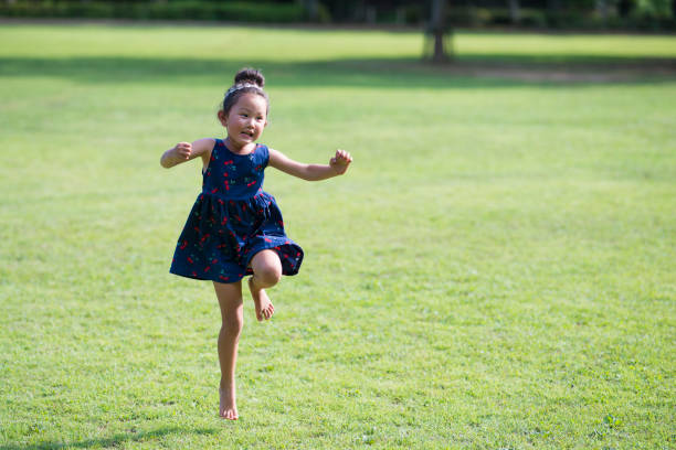 niñas jugando en el césped - child dancing preschooler outdoors fotografías e imágenes de stock