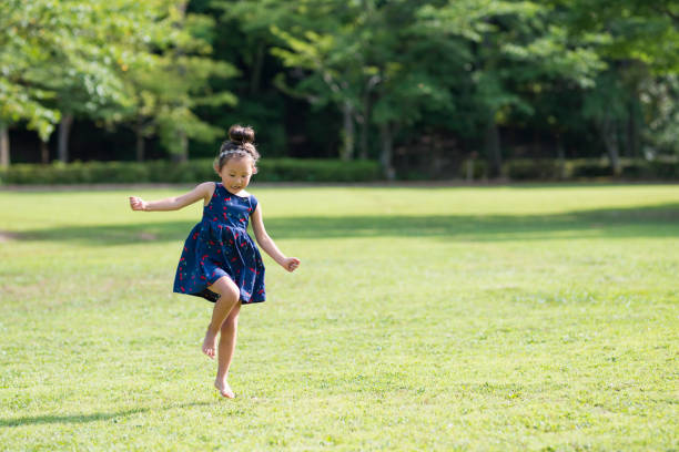 niñas jugando en el césped - child dancing preschooler outdoors fotografías e imágenes de stock