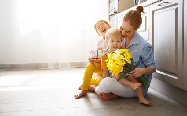 szczęśliwy dzień matki! dzieci gratulują mamom i dają jej prezent i kwiaty - flower spring bouquet child zdjęcia i obrazy z banku zdjęć