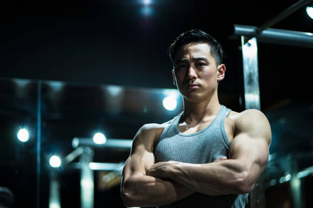Japanese body builder posing at gym