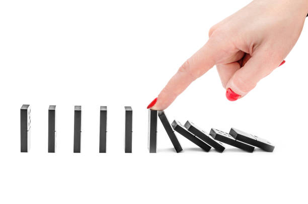 istock Woman's hand stopping domino effect on white background. 943971308