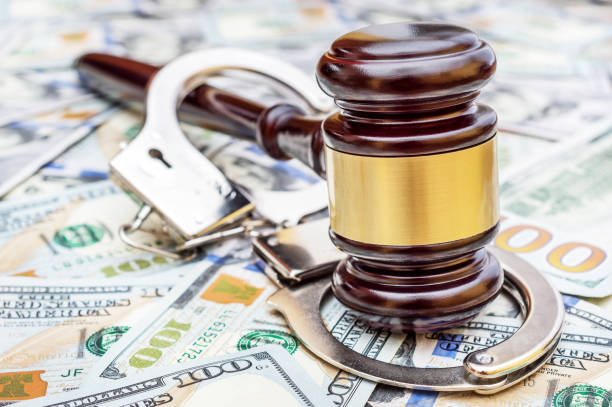 istock Gavel with handcuffs on the background of dollar. 943971468