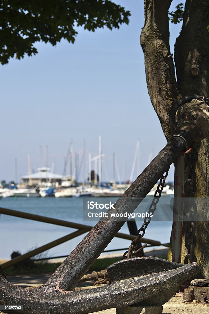 Large historic anchor at waters edge  Anchor - Vessel Part Stock Photo