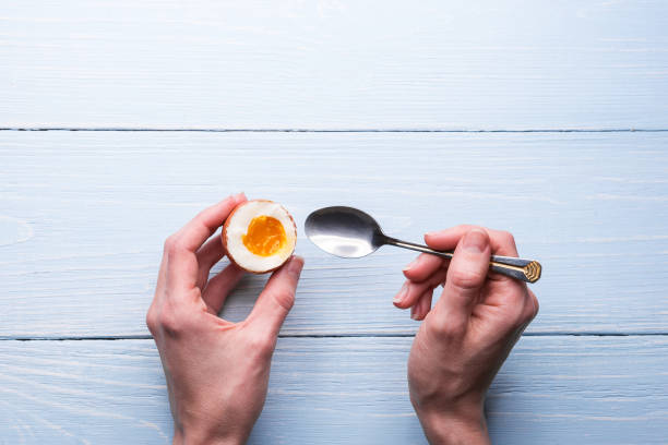 boiled eggs in hands on a wooden background stock photo