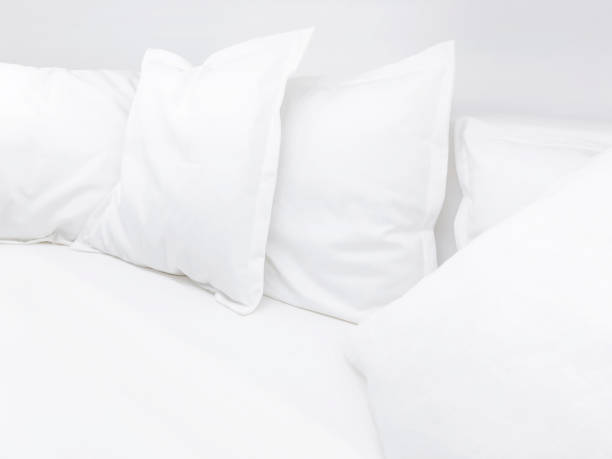 istock Few white pillows on bed. Clear white bed linen for restful sleep. 943979686