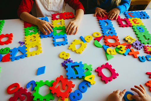 kids playing with number and shapes puzzle, learning concept