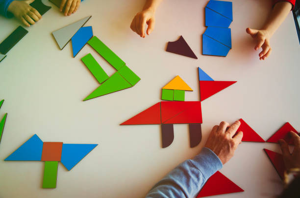 istock teacher and kids play with puzzle or tangram, education 943982320