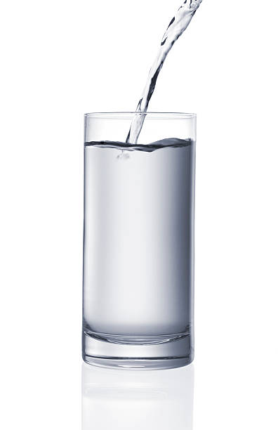 Cтоковое фото Наливать стаканом воды-изолированные