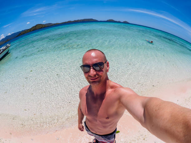 istock Caucasian man makes selfie at the Flores Taka Makassar Beach 943985802