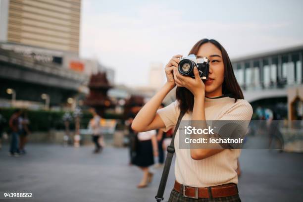 Young Asian Woman Traveler In Bangkok Downtown District Holding A Vintage Film Camera Stock Photo - Download Image Now