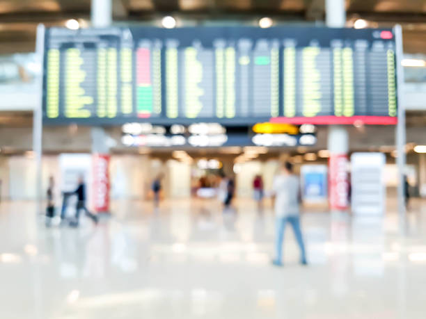 istock blurred people looking at time schedule in the airport 943993124