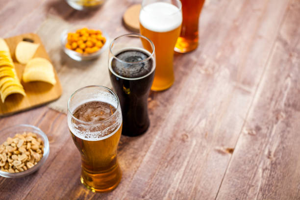 istock glasses of light and dark beer with assorted snacks on a wooden table background with copy space for text. bachelor party, pub, bar or degustation concept 943995896
