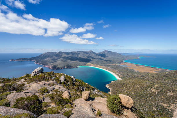 rilassante incredibile vista sulle montagne vista mozzafiato sull'acqua blu della spiaggia sabbiosa di wineglass bay e goditi il caldo cielo blu soleggiato dopo aver fatto un'escursione in cima, il freycinet national park, il monte amos, la tasmania, l'aus - freycinet national park foto e immagini stock