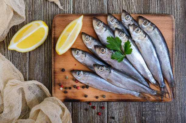 istock A small salted hamsa (sprat) with spices, lemon on a wooden background. Top view. 944001008
