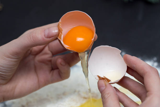 istock Chicken eggs in white plate and slide around her meal with a broken egg. The process of making of the test. Eggs, flour, a plate on a black background. 944001334