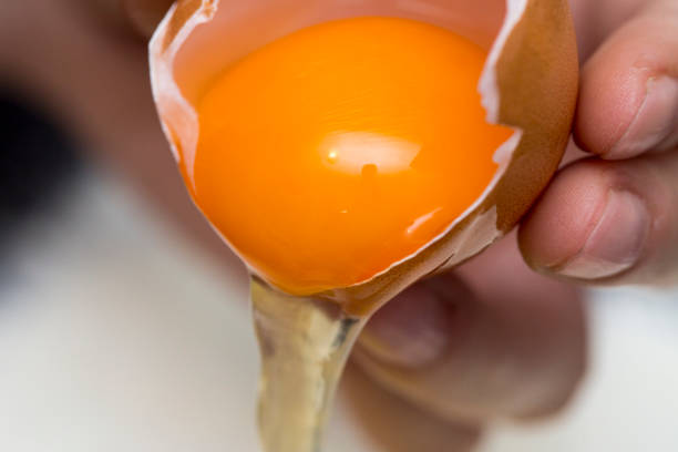 istock Chicken eggs in white plate and slide around her meal with a broken egg. The process of making of the test. Eggs, flour, a plate on a black background. 944003812