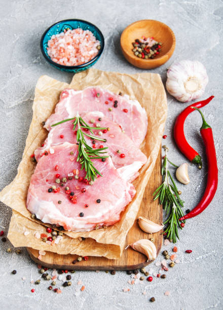 istock Fresh raw pork chops with spices and herbs 944004288