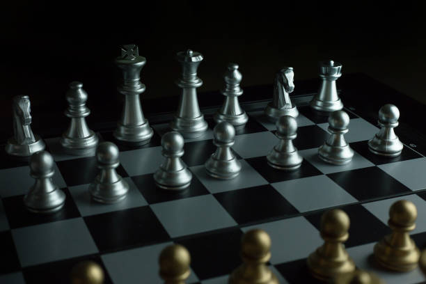 istock gold and silver chess on board close up image abstract Background. 944011700
