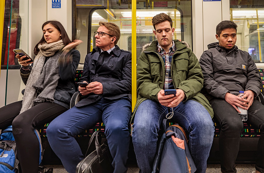 London, England - March 20, 2018: Four passengers in the famous London underground train