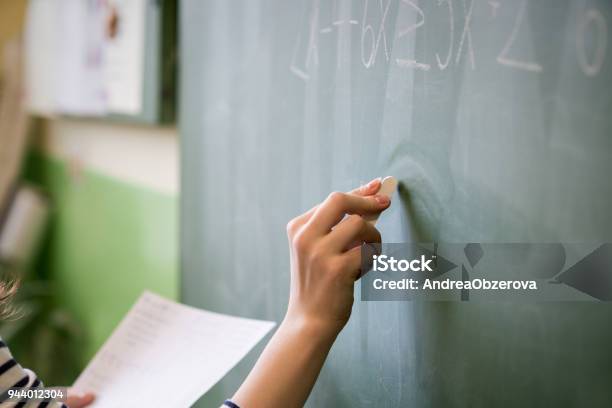 Junge Weibliche Lehrer Oder Student Schriftlich Mathe Formel Auf Tafel Im Klassenzimmer Stockfoto und mehr Bilder von Lehrkraft