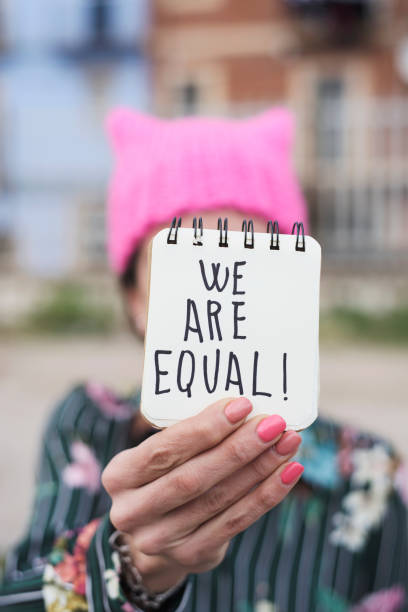 istock woman with a pink hat and the text we are equal 944019550