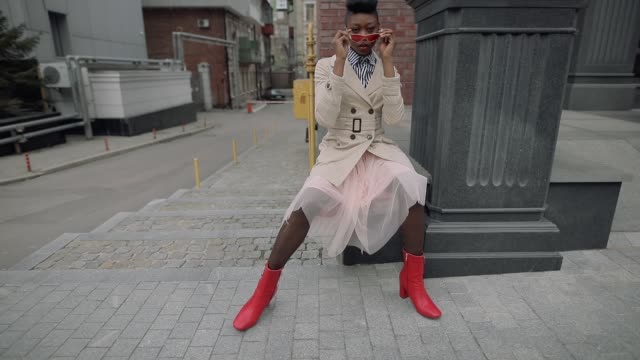 Stylish fashionable woman blogger sitting in urban city