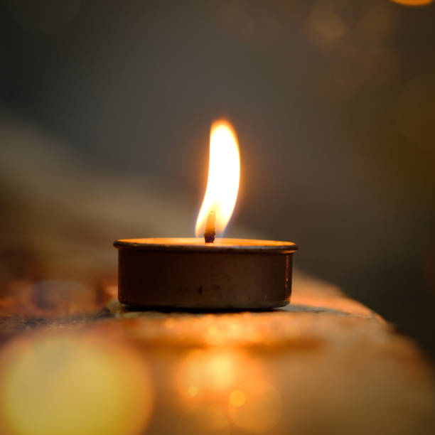istock Prayer and hope concept.Candle flame light at night with abstract circular bokeh background 944025516